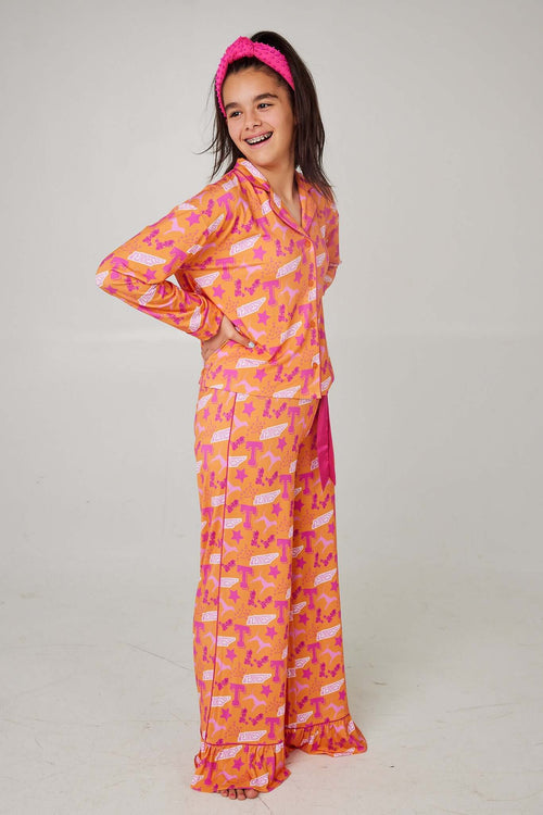 Girl wearing bright Tennessee Tranquility Time Gameday Pajamas with fun pink patterns and matching headband.