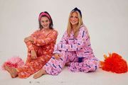 Two girls; one wearing Tennessee Tranquility Time Gameday Pajamas in a colorful pattern, showcasing comfort and style.